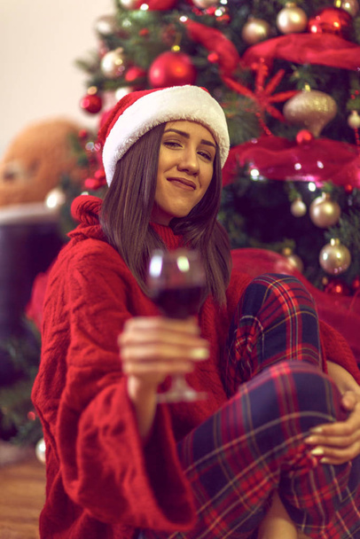 Різдво і Новий рік. Жінка в капелюсі Санти тримає гальсу
  - Фото, зображення