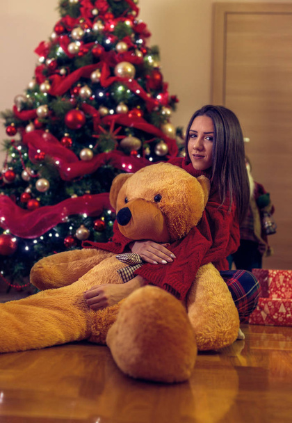 Дівчина і Різдво Подарунок плюшевий ведмедик
.  - Фото, зображення