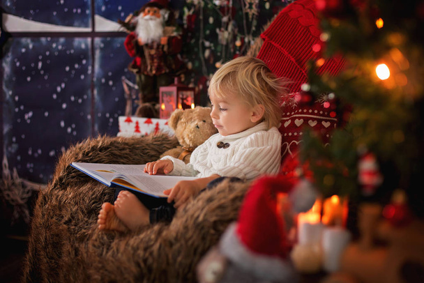 Aranyos kisgyerek, ül körül karácsonyfa hangulatos szék, r - Fotó, kép
