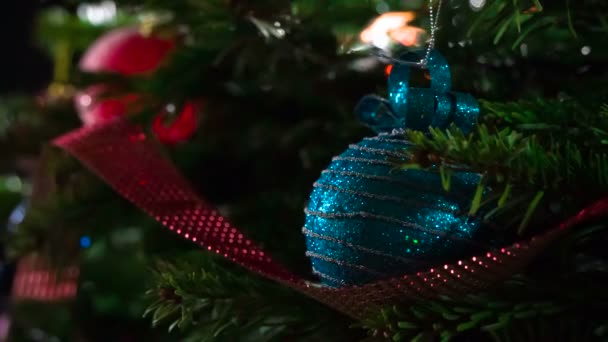 Magic of Christmas Shine. Christmas tree branches decorated with bright sparkling garlands and Christmas decorations are slowly moving in front of the camera - Footage, Video