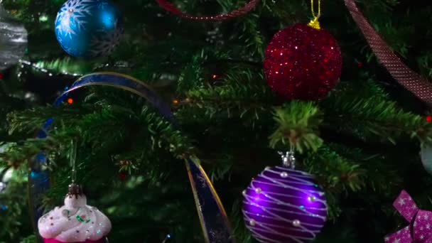 Weihnachtsbaum geschmückt für das neue Jahr. Mit funkelnden Girlanden und Weihnachtsschmuck geschmückte Christbaumzweige bewegen sich langsam vor der Kamera - Filmmaterial, Video