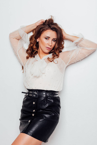 portrait of a beautiful fashionable woman with hair curls in a blouse and black skirt - Photo, Image