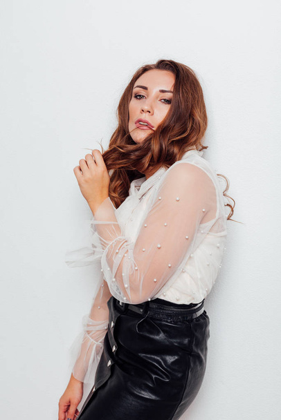 portrait of a beautiful fashionable woman with hair curls in a blouse and black skirt - Foto, afbeelding