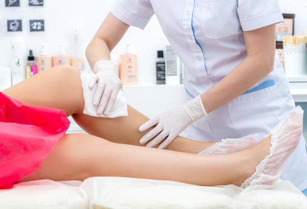beautician hair removal procedure on the client's feet in beauty parlor - Photo, Image