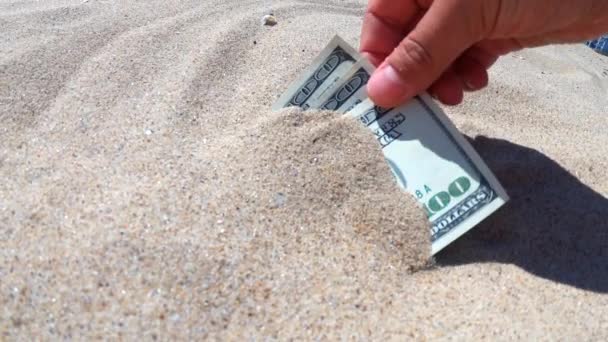 Ένα κορίτσι παίρνει από την άμμο χαρτονομίσματα των τριακοσίων δολαρίων. - Πλάνα, βίντεο