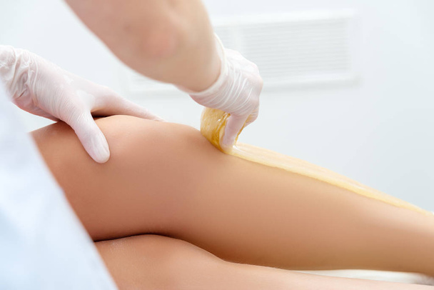beautician hair removal procedure on the client's feet in beauty parlor - Foto, immagini