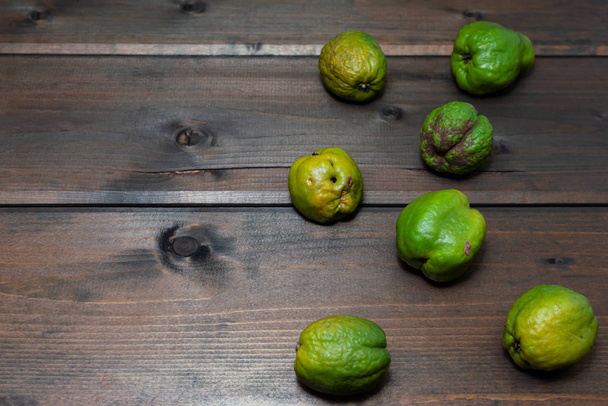 quince, trendy ugly chinese pear on a wooden dark background with place for text. - Фото, зображення