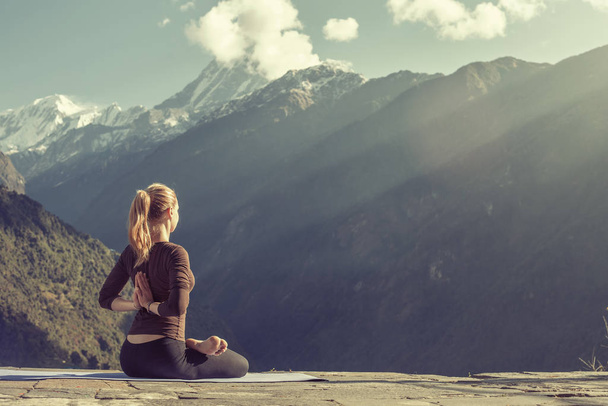 Young girl doing yoga fitness exercise outdoor in beautiful mountains landscape. Morning sunrise, Namaste Lotus pose. Meditation and Relax - Foto, imagen