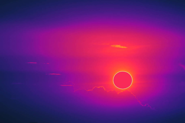 asombroso fenómeno de eclipse total de sol sobre la puesta de sol de nubes naranja
 - Foto, Imagen