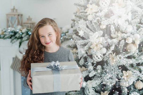 Happy excited girl child holding christmas gift box. - Foto, Imagen
