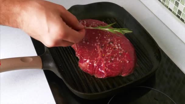 Man Hand Putting Twig of Rosemary on Grilled Beef Steak with Salt and Pepper - Filmati, video