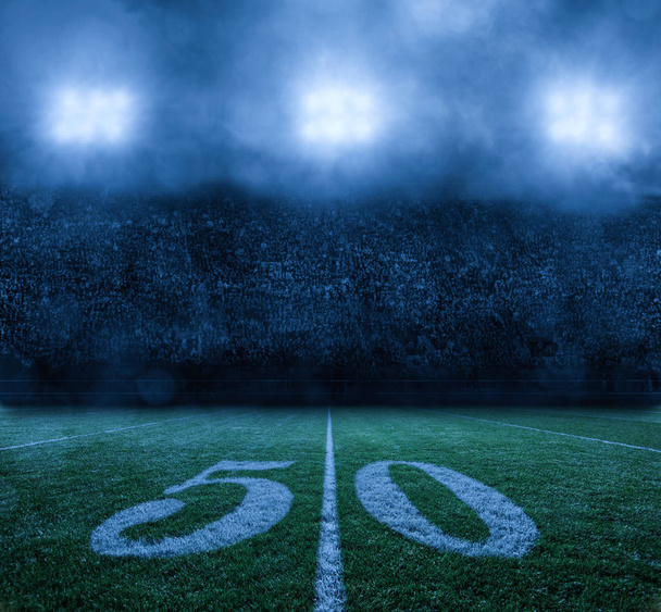 American Football Stadium 's nachts 50 yard lijn. Stadion licht op een mistige bewolkte nacht. Niemand op de foto, alleen de achtergrond. - Foto, afbeelding