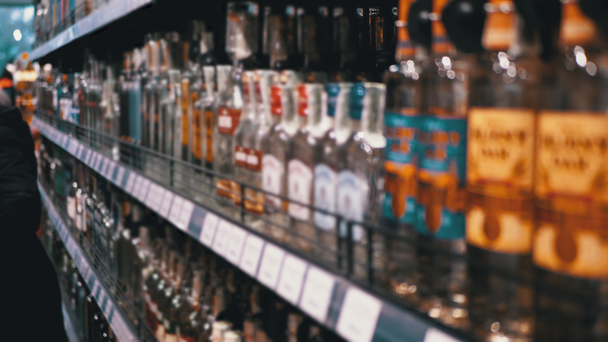 Alkoholverkauf im Supermarkt. Reihen und Regale mit abgefülltem Alkohol in einem Schaufenster - Filmmaterial, Video