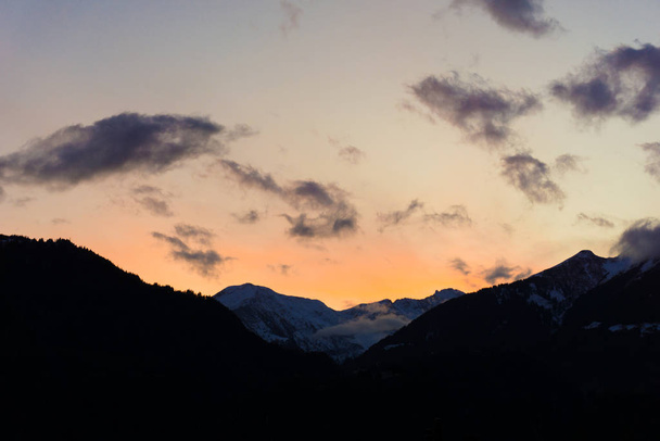 colorful winter sunset over snowy mountain landscape with dark f - Foto, imagen