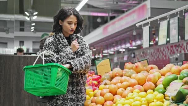 African american woman shopping grapefruits in market. Woman take grapefruit - Кадри, відео