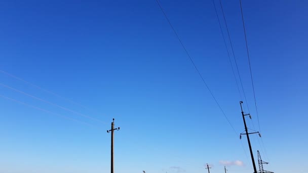 Dwa rzędy linii energetycznych w tle niebieskiego nieba - Materiał filmowy, wideo