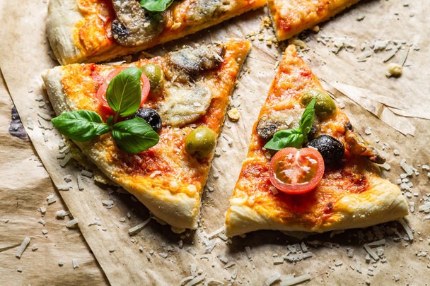 Nahaufnahme von hausgemachter Pizza mit Tomate und Basilikum - Foto, Bild