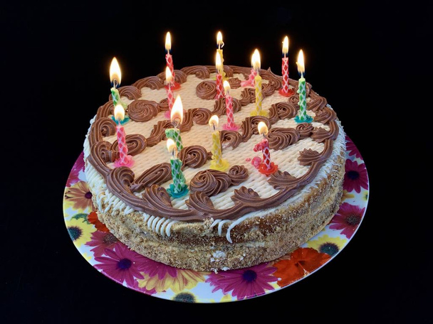Круглий торт зі свічками, на чорному тлі. Подарунок на день народження для підлітка. Святковий десерт для всієї родини
. - Фото, зображення