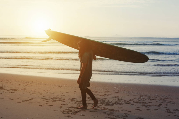 Silhouette of Male surfer with long board on the sea sunset  - Foto, imagen