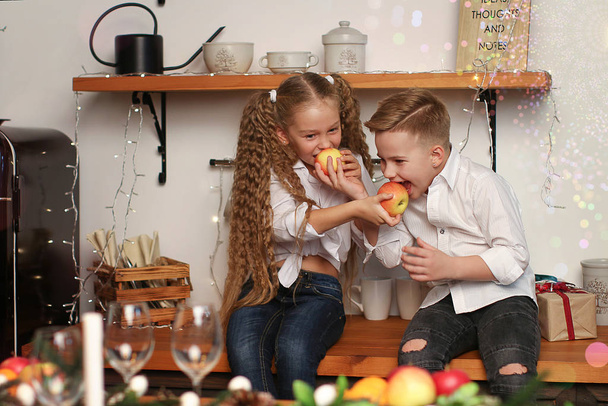 Ragazzo e ragazza festeggiano il nuovo anno, bevono succo, mangiano frutta e formulano desideri nelle decorazioni di Capodanno.
 - Foto, immagini
