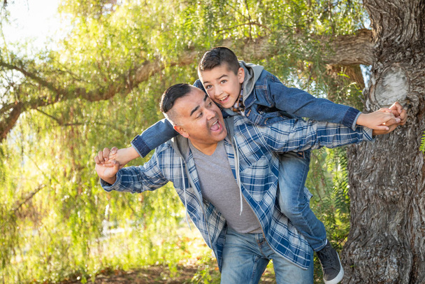Mixed Race Father And Son Having Fun Piggy Back Outdoors - Foto, Imagem