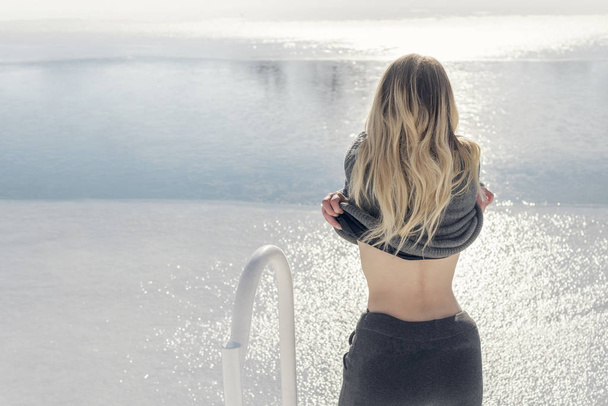 Woman undresses by the water - Valokuva, kuva