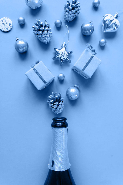 Champagne bottle with different christmas decoration on blue background. New year concept. - Photo, Image