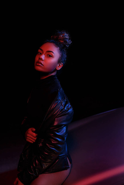 a young beautiful afro-american girl in a leather jacket, in a b - Photo, Image