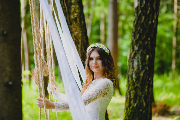Beautiful young bride posing near the rope swing - Φωτογραφία, εικόνα