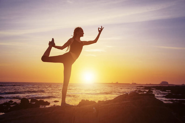 Female yoga silhouette on sea sunset - Foto, Bild