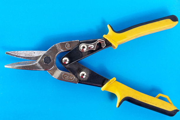 Scissors for metal. Tool for cutting sheet metal on a blue background. - Foto, afbeelding