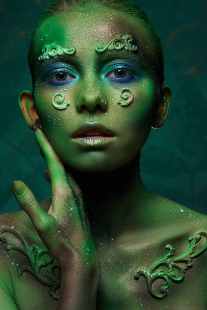 dziewczyna z kreatywnym zielony makijaż na obraz ducha lasu  - Zdjęcie, obraz