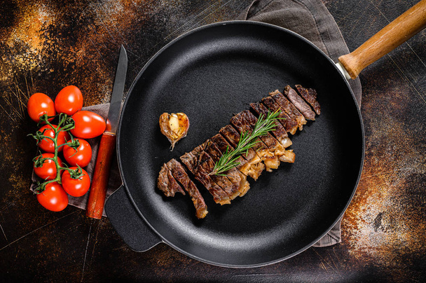 Beef New York Streifen Steak in einer Pfanne braten. Raum für Text. Marmor Premium Rindfleisch. dunkler Hintergrund - Foto, Bild