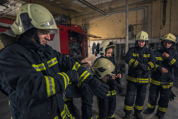 Пожежники готуються до служби швидкої допомоги. Пожежники одягають рукавички
. - Фото, зображення