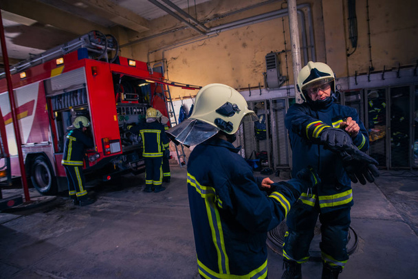 Πυροσβέστες ετοιμάζουν τη στολή τους και το πυροσβεστικό στη μπα - Φωτογραφία, εικόνα
