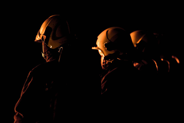 Пожарная команда в полной форме во время срочного огневого вмешательства. - Фото, изображение