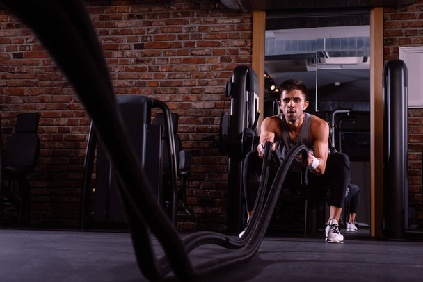 svalnatý muž dělá bojové lano cvičení - Fotografie, Obrázek