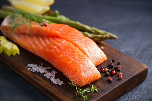 Fresh raw salmon fillet steak with vegetables and ingredients prepared for cooking - Foto, imagen