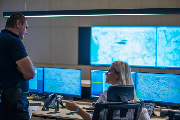 Security guards working in surveillance room, monitoring cctv and discussing. - Photo, Image