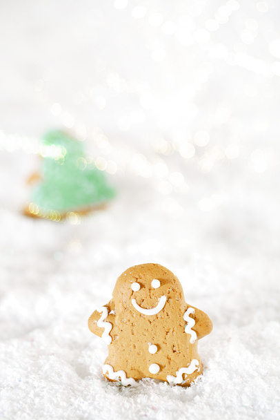 Пряничний чоловік і ялинка на святковому різдвяному снігу
 - Фото, зображення