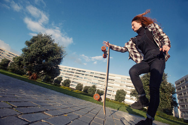 Young happy female riding on skate longboard outdoor - Fotografie, Obrázek