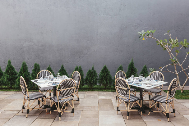 Restaurant tables outdoor with little Christmas trees and grey wall on background  - Foto, Imagem