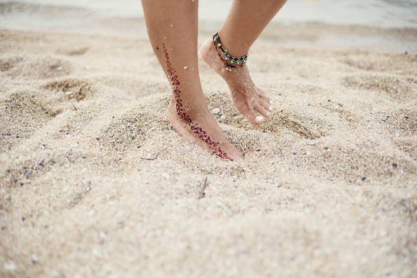 Woman legs on sea shore - Фото, изображение