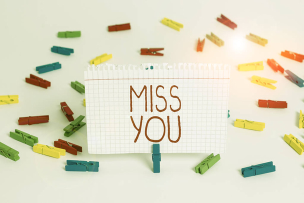 Writing note showing Miss You. Business photo showcasing Feeling sad because you are not here anymore loving message Colored clothespin papers empty reminder white floor background office. - Photo, Image