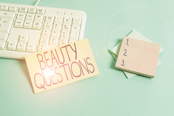 Text sign showing Beauty Questions. Conceptual photo a sentence or phrase used to find out information Paper blue desk computer keyboard office study notebook chart numbers memo. - Photo, Image