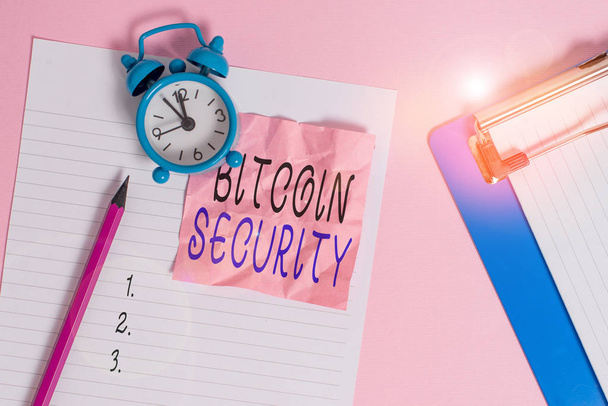 Handwriting text writing Bitcoin Security. Concept meaning funds are locked in a public key cryptography system Paper sheet note clipboard pencil vintage alarm clock colored background. - Photo, Image