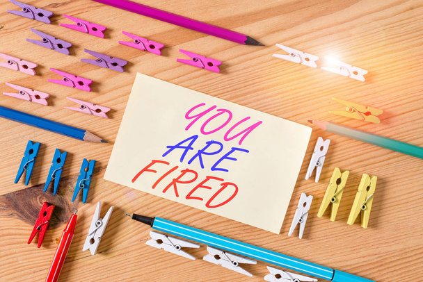 Handwriting text You Are Fired. Concept meaning Getting out from the job and become jobless not end the career Colored clothespin papers empty reminder wooden floor background office. - Photo, Image