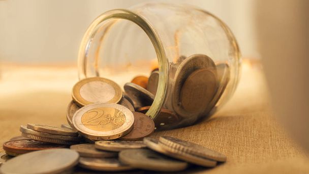 Ένα βάζο νομισμάτων αναποδογύρισε στο τραπέζι με κέρματα ευρώ. Αυτή η εικόνα c - Φωτογραφία, εικόνα