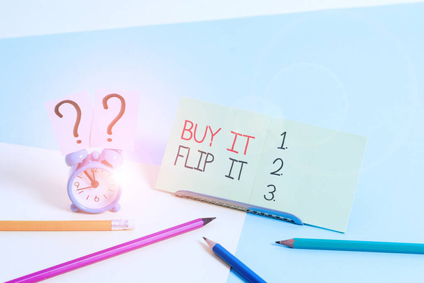Znak tekstowy pokazujący Buy It Flip It. Koncepcyjne zdjęcie Kup coś je naprawić, a następnie sprzedać je dla większego zysku Mini rozmiar budzik obok stacjonarne umieszczone przechylone na pastelowym tle. - Zdjęcie, obraz