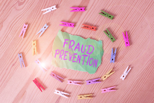 Word writing text Fraud Prevention. Business concept for the act of stopping various types of internet fraud Colored clothespin papers empty reminder wooden floor background office. - Photo, Image